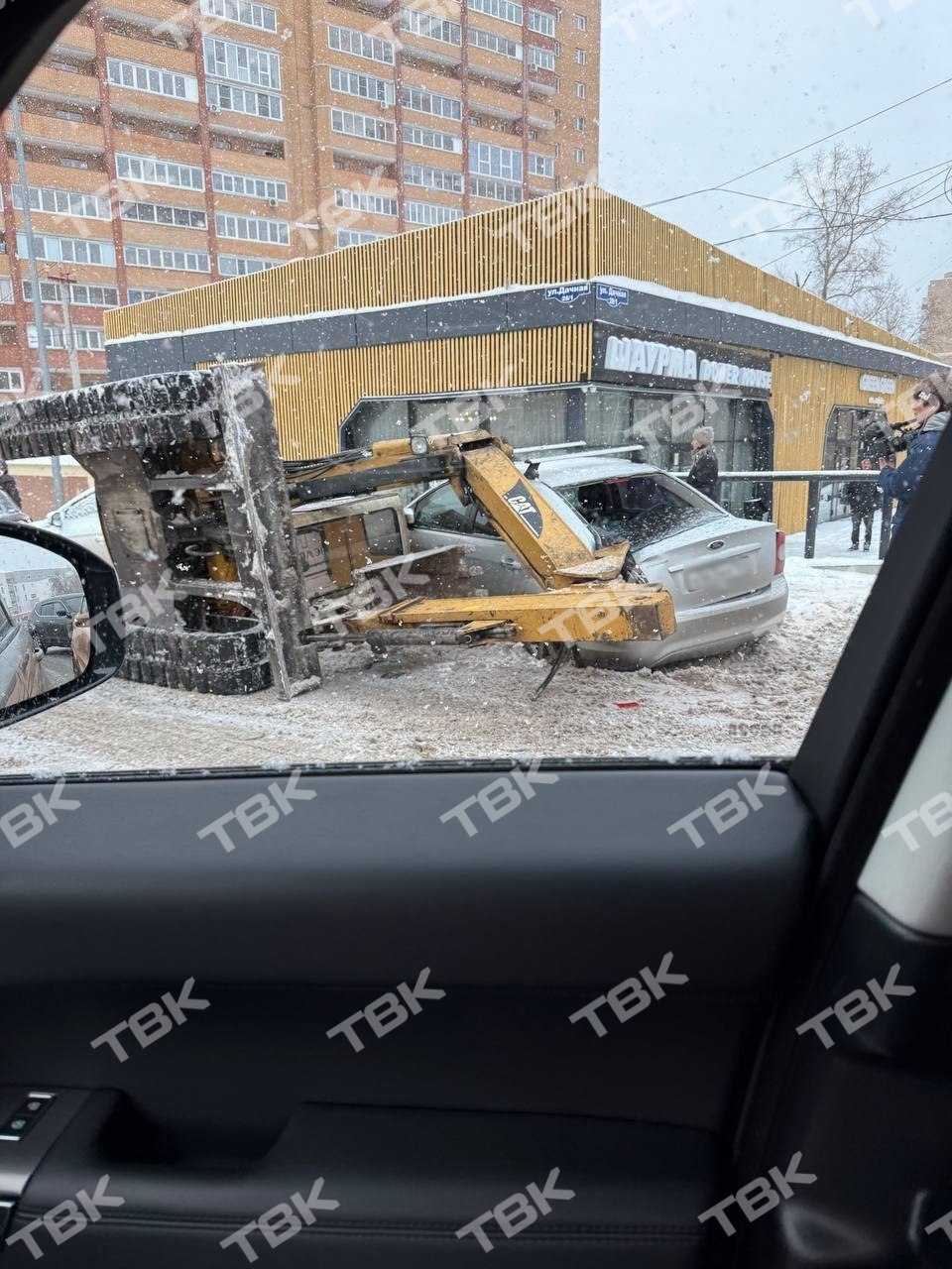 Экскаватор упал с грузовика на машину в Студгородке Экскаватор упал с грузовика на машину в Студгородке