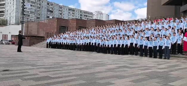 На ступенях музейного центра «Площадь Мира» более 300 школьников исполняют песни Победы